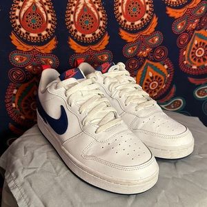 White, red and blue Nike shoes. They are size 7Y but fit size 8 in women’s.